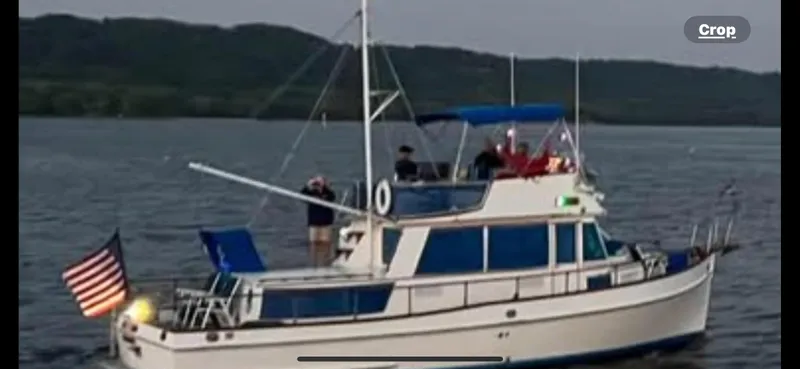 Slide: The Image of 1978 Grand Banks 36 Classic yacht on water, American flag, scenic background. - 41