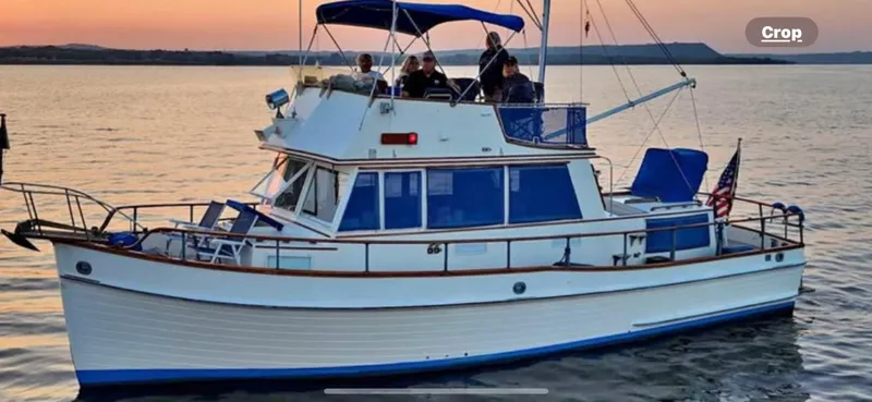 Slide: The Image of 1978 Grand Banks 36 Classic boat cruising at sunset with passengers on deck. - 42