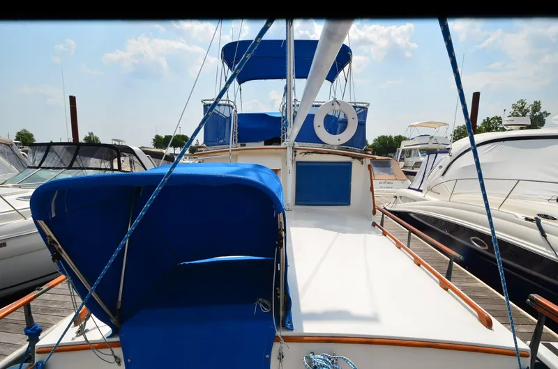 Slide: The Image of 1978 Grand Banks 36 Classic yacht with blue canopy docked at marina. - 5
