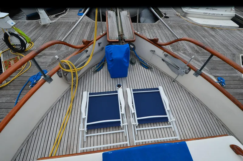 Slide: The Image of 1978 Grand Banks 36 Classic yacht deck with blue chairs and wooden railings. - 6