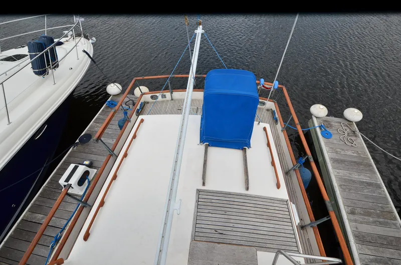 Slide: The Image of 1978 Grand Banks 36 Classic yacht docked, featuring a spacious deck with blue cover. - 9