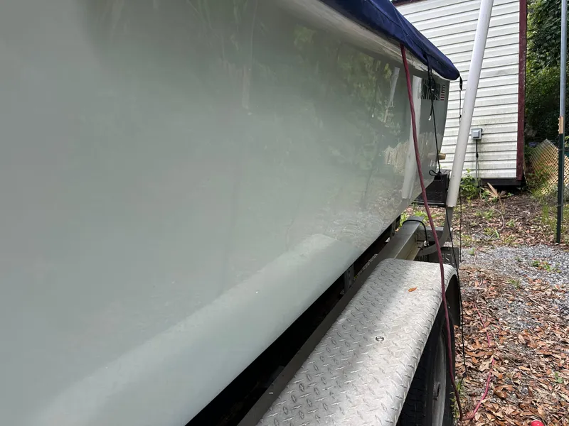 Slide: The Image of 1985 Contender 25 Classic boat on trailer, side view near house. - 10