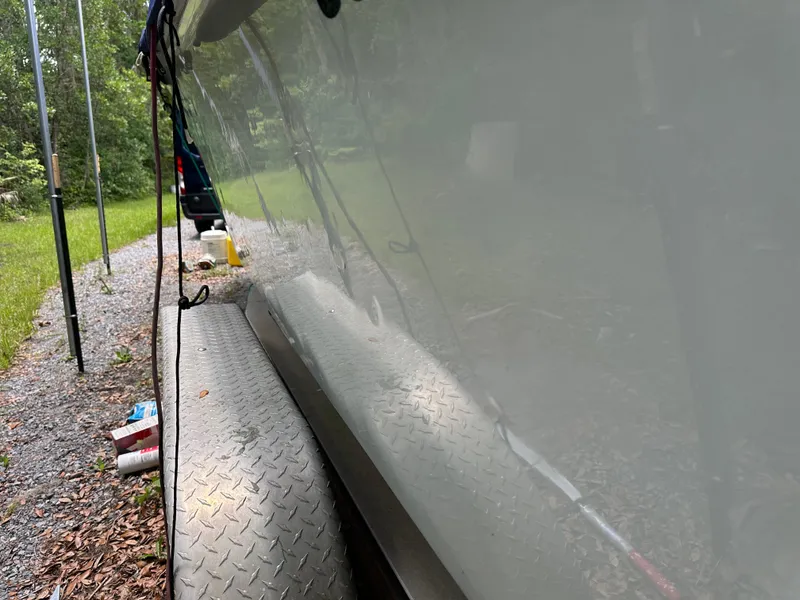 Slide: The Image of 1985 Contender 25 Classic boat on trailer, reflecting surroundings in a wooded area. - 11