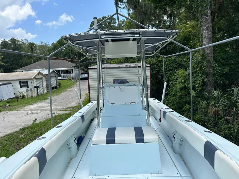 Slide: The Image of 1985 Contender 25 Classic boat with center console, parked outdoors near trees and houses. - 14