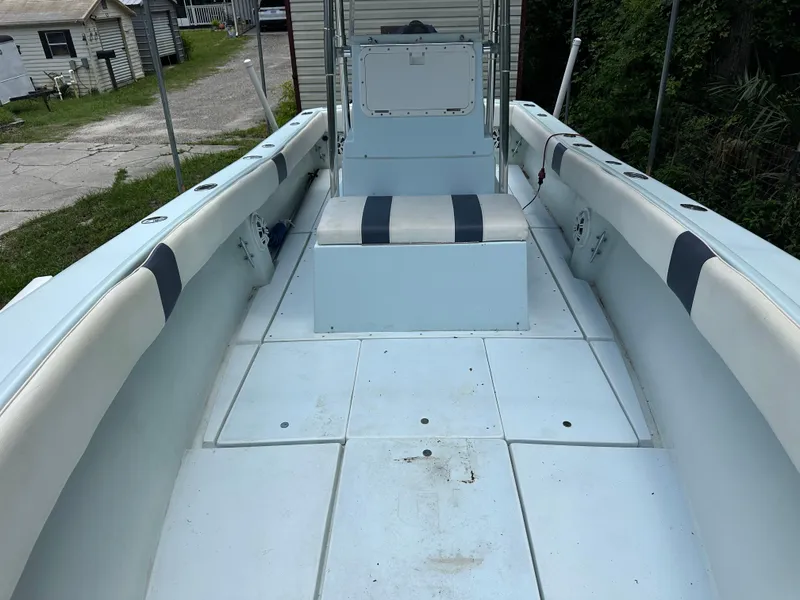 Slide: The Image of 1985 Contender 25 Classic boat interior with seating and storage, docked near residential area. - 15