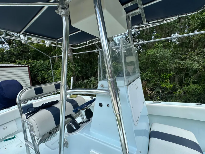 Slide: The Image of 1985 Contender 25 Classic boat interior with seating and canopy, surrounded by lush greenery. - 22