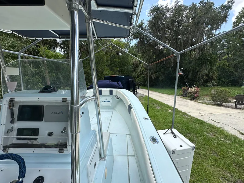 Slide: The Image of 1985 Contender 25 Classic boat with canopy, parked on grassy driveway near trees. - 24