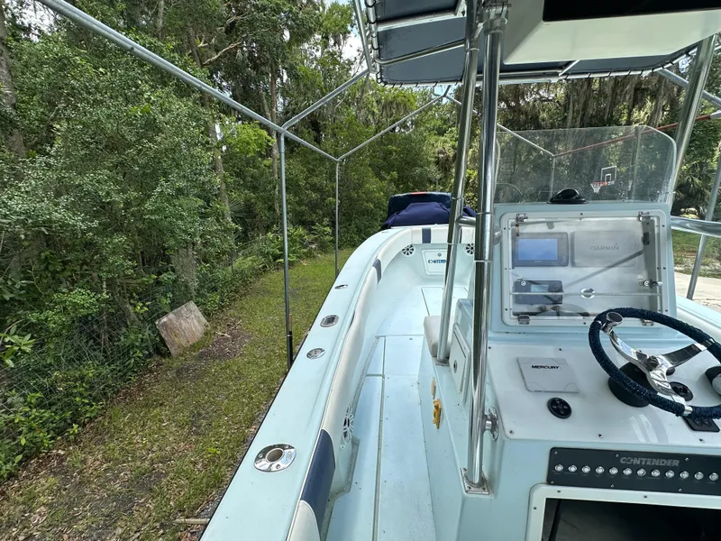 Slide: The Image of 1985 Contender 25 Classic boat with console, parked outdoors near trees. - 28