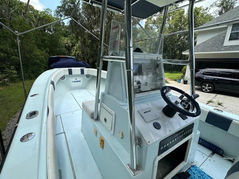 Slide: The Image of 1985 Contender 25 Classic boat with center console, parked outdoors near a house and trees. - 29