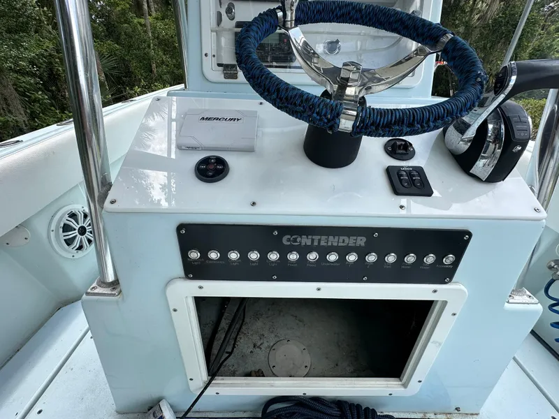 Slide: The Image of 1985 Contender 25 Classic boat dashboard with steering wheel and control panel. - 30