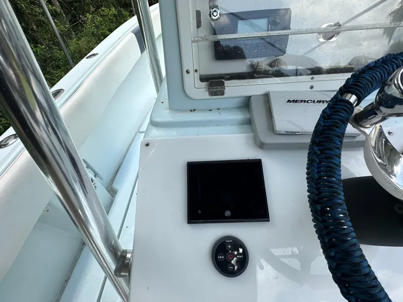 Slide: The Image of 1985 Contender 25 Classic boat dashboard with steering wheel and Mercury controls. - 33