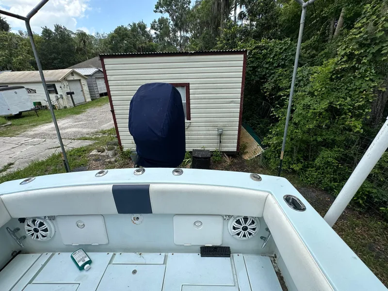 Slide: The Image of 1985 Contender 25 Classic boat interior with speakers, near a small shed and greenery. - 37
