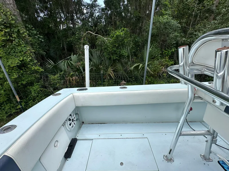 Slide: The Image of 1985 Contender 25 Classic boat interior with seating and railing, surrounded by lush greenery. - 43