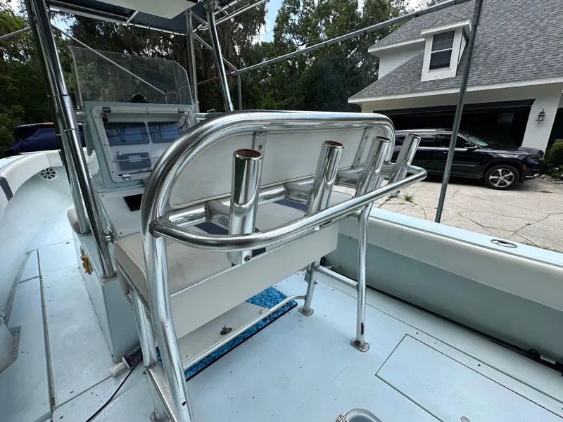 Slide: The Image of 1985 Contender 25 Classic boat interior with rod holders and console, parked near a house. - 45