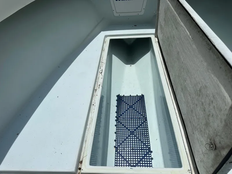 Slide: The Image of 1985 Contender 25 Classic boat storage compartment with open lid and non-slip mat. - 49