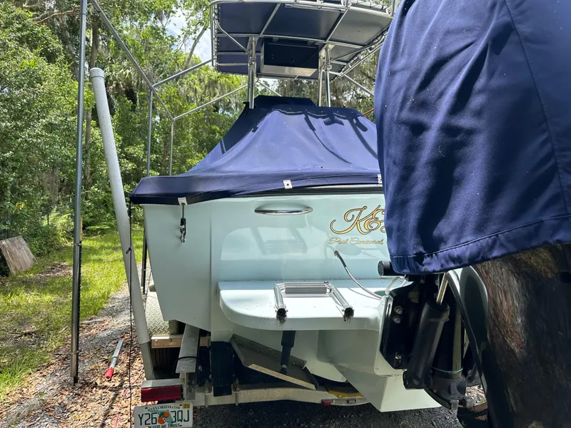 Slide: The Image of 1985 Contender 25 Classic boat on trailer, covered, in wooded area. - 6