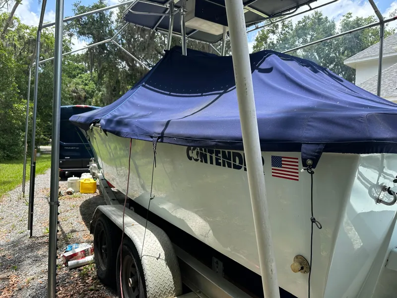 Slide: The Image of 1985 Contender 25 Classic boat with blue cover on trailer, parked outdoors. - 7