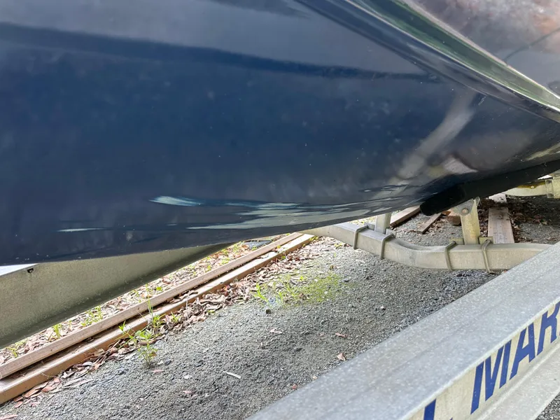 Slide: The Image of 1985 Contender 25 Classic boat hull on trailer, showing underside and blue paint. - 9