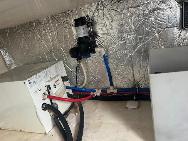 Slide: The Image of 2013 Rinker 290 Express Cruiser engine compartment with wiring and plumbing components. - 11