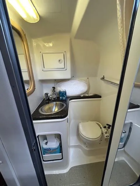 Slide: The Image of 2013 Rinker 290 Express Cruiser bathroom with sink, toilet, and storage. - 24