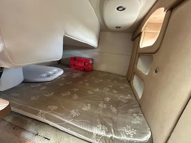 Slide: The Image of 2013 Rinker 290 Express Cruiser cabin interior with bed and storage. - 26