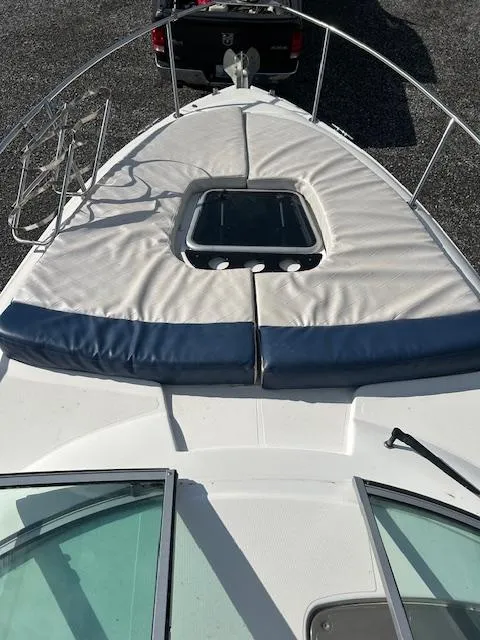 Slide: The Image of 2013 Rinker 290 Express Cruiser boat deck with cushioned seating and hatch. - 28