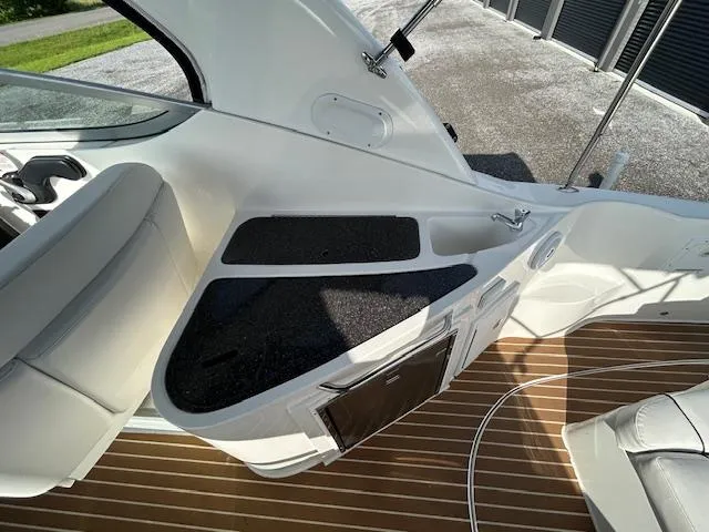 Slide: The Image of 2013 Rinker 290 Express Cruiser interior with sleek seating and wood-patterned flooring. - 35