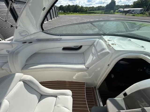 Slide: The Image of 2013 Rinker 290 Express Cruiser interior with white seating and wood flooring. - 41