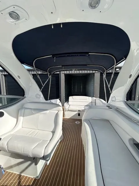 Slide: The Image of 2013 Rinker 290 Express Cruiser interior with white seating and canopy. - 43