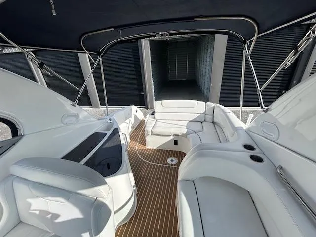 Slide: The Image of 2013 Rinker 290 Express Cruiser interior with white seating and wood flooring. - 45