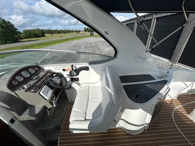 Slide: The Image of 2013 Rinker 290 Express Cruiser cockpit with white seating and modern dashboard controls. - 46