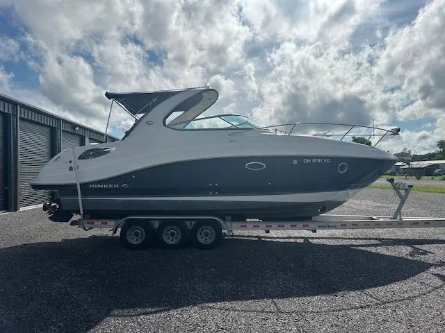 Slide: The Image of 2013 Rinker 290 Express Cruiser on trailer under cloudy sky. - 7