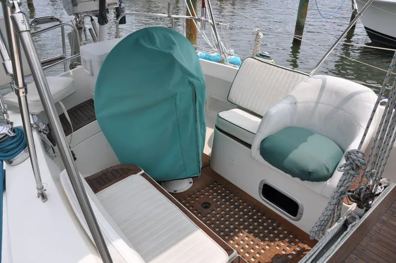 Slide: The Image of 1986 Scanmar 33 sailboat cockpit with cushioned seating and covered helm, docked at marina. - 10