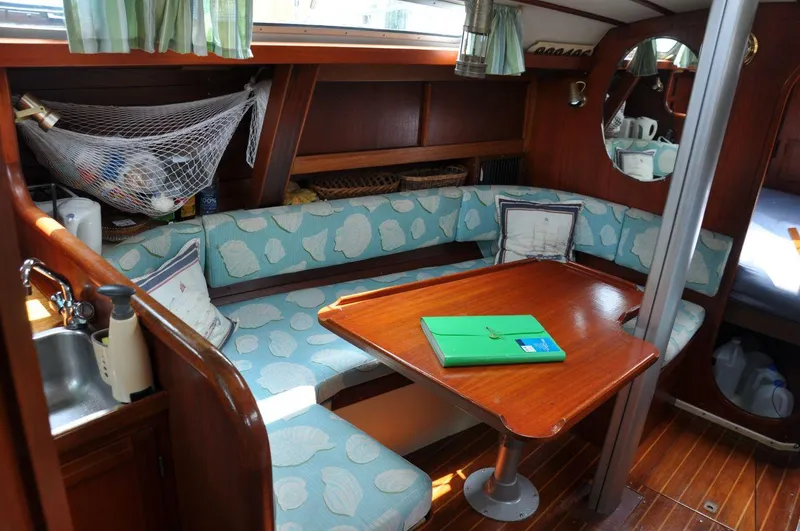 Slide: The Image of Cozy interior of 1986 Scanmar 33 sailboat with cushioned seating and wooden table. - 17