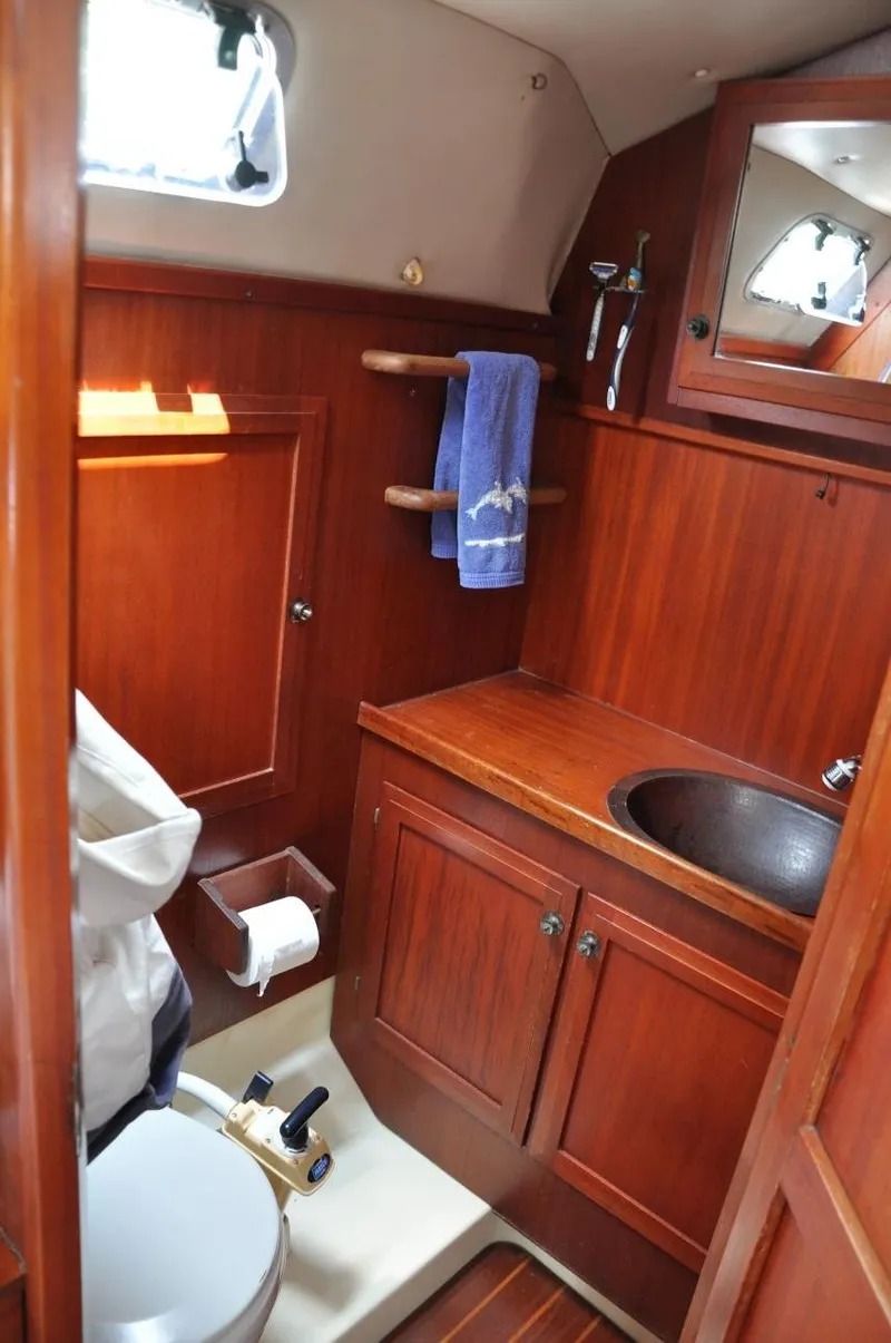 Slide: The Image of 1986 Scanmar 33 yacht bathroom with wooden cabinetry and compact design. - 20