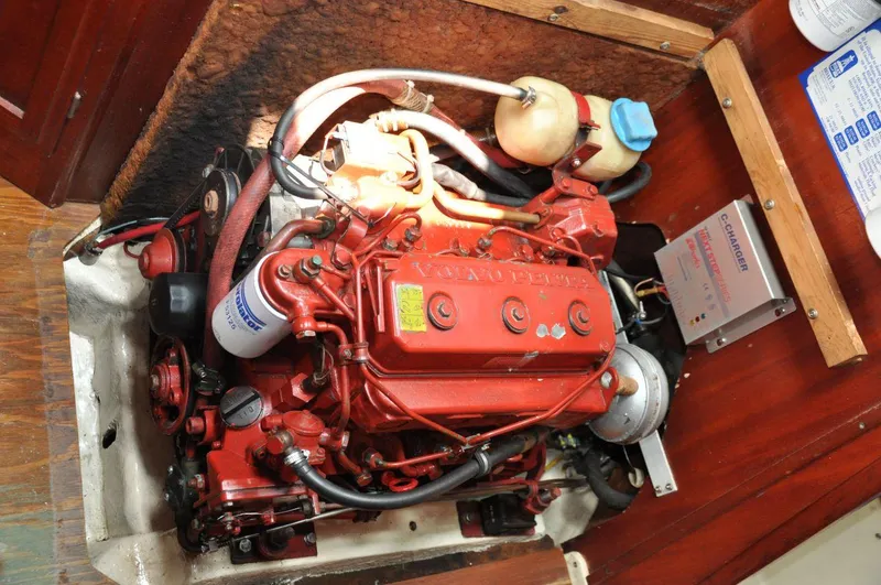Slide: The Image of Engine compartment of a 1986 Scanmar 33 sailboat, featuring a red marine engine. - 22