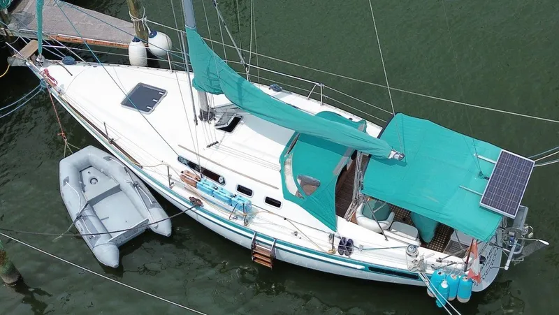 Slide: The Image of Aerial view of 1986 Scanmar 33 sailboat with teal covers and attached dinghy. - 4
