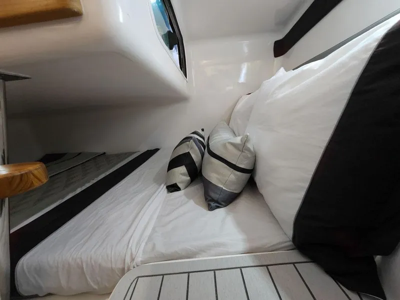 Slide: The Image of Cozy cabin interior of 2025 Hanover 305 Inboard with modern bedding and cushions. - 11