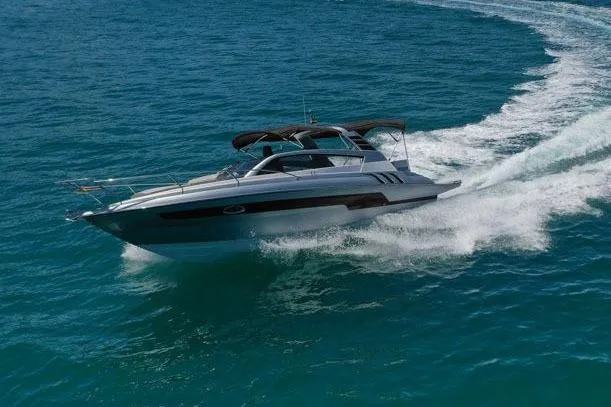 Slide: The Image of 2025 Hanover 305 Inboard cruising on open sea with scenic mountain backdrop. - 3