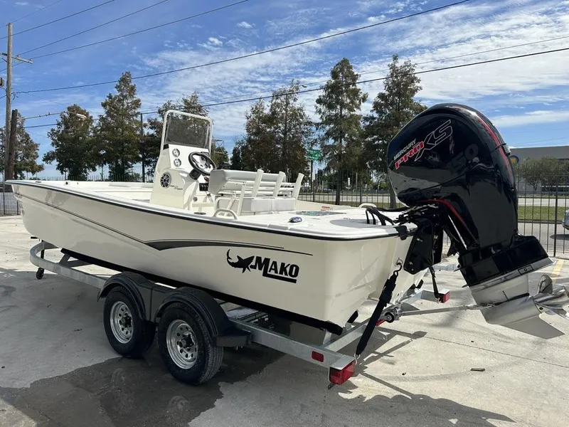 Slide: The Image of 2024 Mako Pro Skiff 19 CC boat on trailer with Mercury engine, parked outdoors. - 4
