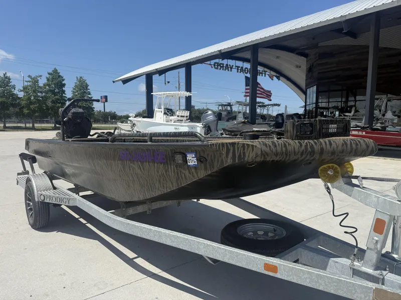 Slide: The Image of 2024 Prodigy 17x51 boat on trailer, parked outdoors near a boat yard. - 11