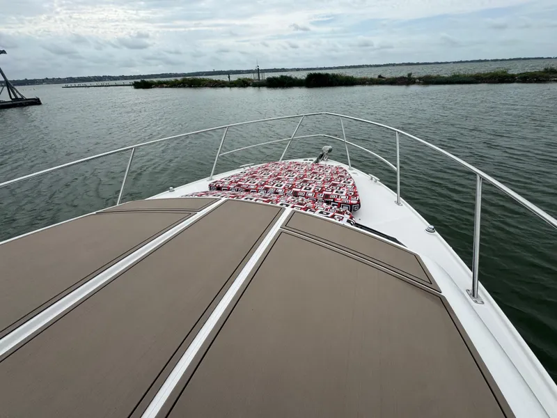 Slide: The Image of 2011 Regal 35 Express Cruiser on calm water, featuring spacious deck and scenic view. - 10