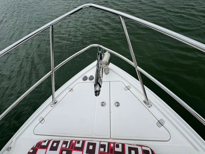 Slide: The Image of Bow of 2011 Regal 35 Express Cruiser on water, featuring stainless steel railings. - 11