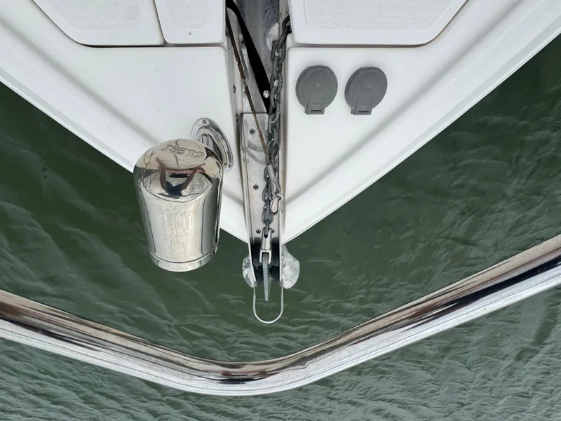 Slide: The Image of Bow of 2011 Regal 35 Express Cruiser over water, featuring anchor and stainless steel fittings. - 12