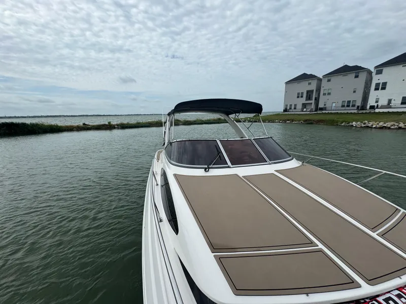 Slide: The Image of 2011 Regal 35 Express Cruiser on calm water near modern houses. - 14