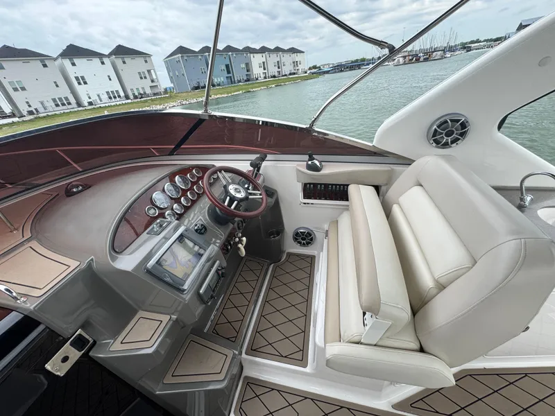 Slide: The Image of 2011 Regal 35 Express Cruiser helm with modern controls, overlooking waterfront homes. - 16