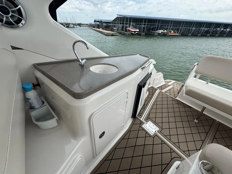Slide: The Image of 2011 Regal 35 Express Cruiser interior with sink, seating, and marina view. - 21