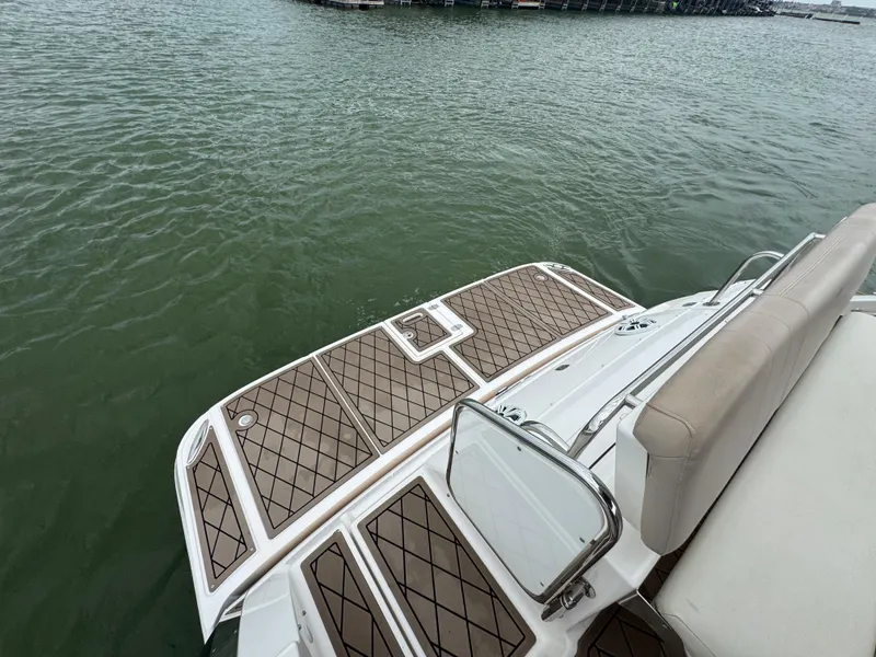 Slide: The Image of 2011 Regal 35 Express Cruiser swim platform with teak-style decking on calm water. - 23