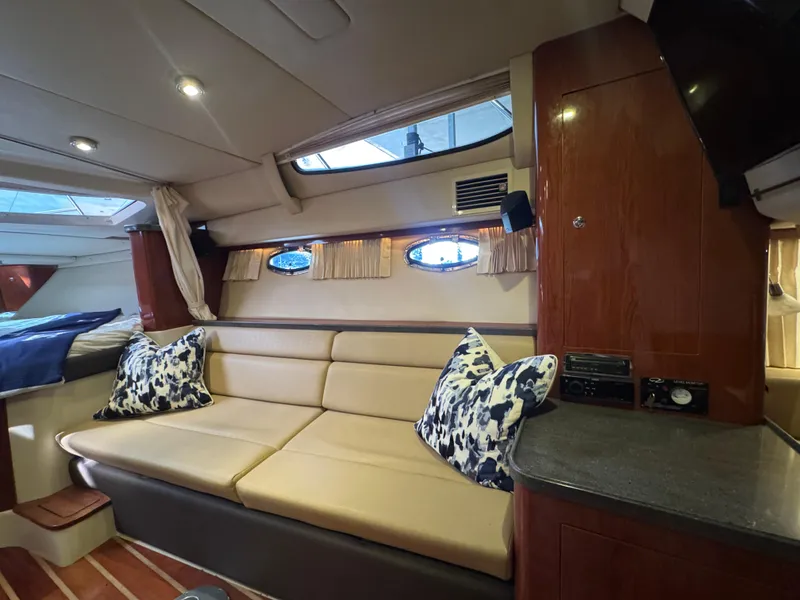 Slide: The Image of Interior of 2011 Regal 35 Express Cruiser with beige seating and decorative pillows. - 33