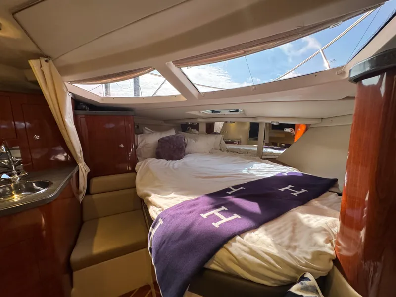 Slide: The Image of Luxurious cabin interior of a 2011 Regal 35 Express Cruiser with skylights and plush bedding. - 35